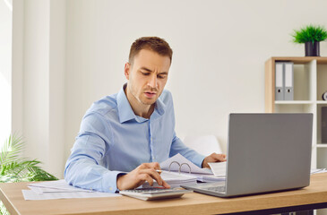 Professional business accountant working in office. Man in shirt sitting at his desk, doing...