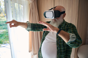 Elderly man plays in virtual reality glasses