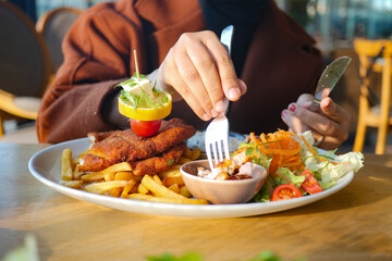 women eating Chicken schnitzel served with potato chips 