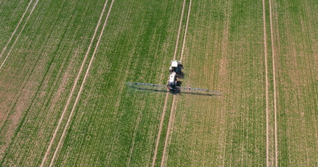 Tractor Spraying Pesticides on Crops at Agriculture Field