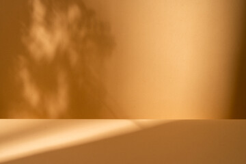 Empty wooden table on brown background with natural shadow on the wall. Mock up for branding...