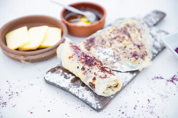 Front view of tasty street, fast food with cheese and honey lying on stylish, wooden board outdoor. Concept of food.