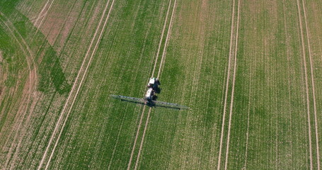 Tractor Spraying Pesticides on Wheat Field