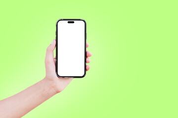 Close-up of male hand holding smartphone with blank on screen isolated on colourful background of green colour. Mockup concept.