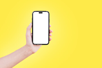 Close-up of male hand holding smartphone with blank on screen isolated on colourful background of yellow colour. Mockup concept.