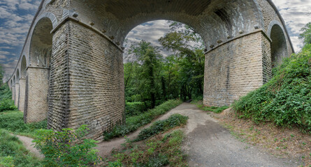 Obraz premium Dardilly, France - 08 05 2023: View of a railway bridge from the bottom of the forest.
