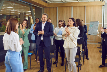 Excited office employees applaud thanking speaker for lecture or business seminar. Overjoyed...