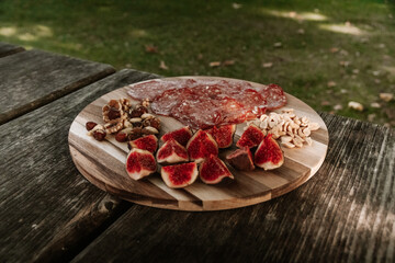 meat and fruits picnic on a cutting board