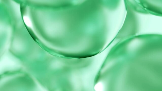 Liquid green oil bubbles macro close up. Abstract cosmetic 3D animation background of fluid circles. Beauty care concept of decorative antioxidant peptide soap spheres in light water background.