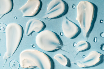 Cosmetic background in blue color with liquid drops and cream touch. Cosmetics for personal care....
