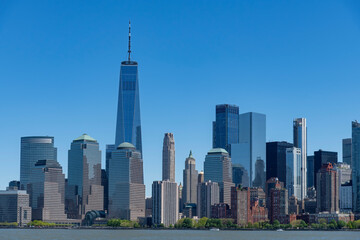 Panoramic view of skyscrapers on the waterfront of lower Manhattan, New York City, NY, USA seen from the Hudson river side against a clear blue sky