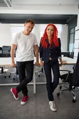 Stylish man and woman marketers leaning on table in coworking space office