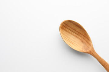 One wooden spoon on white background, top view. Space for text