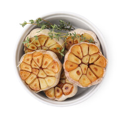 Heads of fried garlic and thyme in bowl isolated on white, top view