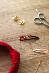 Wooden hairbrush, scissors and various headbands, hair clips and scrunchies on wooden background....