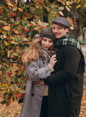 Fototapeta premium Portrait of happy couple in love in autumn park. stylish man and woman in fashion clothes. Vintage look