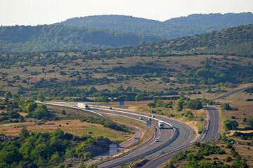 Fototapeta premium Autoroute A75, causse du Larzac, et collines calcaires vers le pas de l'Escalette, réseau routier, infrastructures autoroutières, Hérault, Languedoc Roussillon Sud de la France