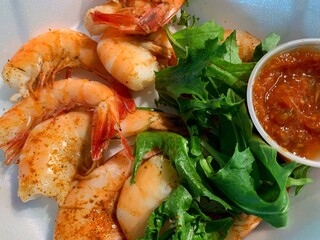 Shrimp appetizer on a plate with lettuce and cocktail sauce