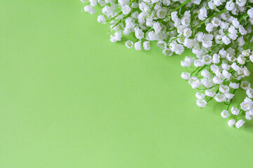 A bouquet of white flowers of oonvalia on a light green background. Copy space. Concept of spring flowers