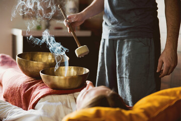 Tibetan singing bowls with smoke in sound therapy in spa center