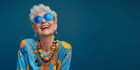 Very bright and happy old woman laughing in stylish glasses on a colored background. Close up shot of positive wrinkled old woman smiles toothily at camera wears glasses stylish outfit applies express