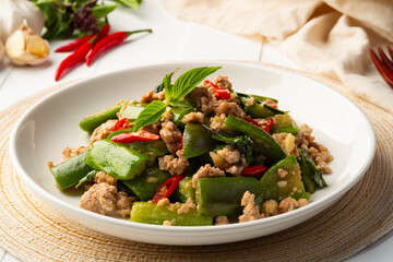 Stir fried Long Eggplant with minced pork and chili basil in white plate