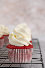 Red velvet cupcakes with cream cheese frosting and red sugar hearts. Delicious dessert for Valentines day. Selective focus, copy space.