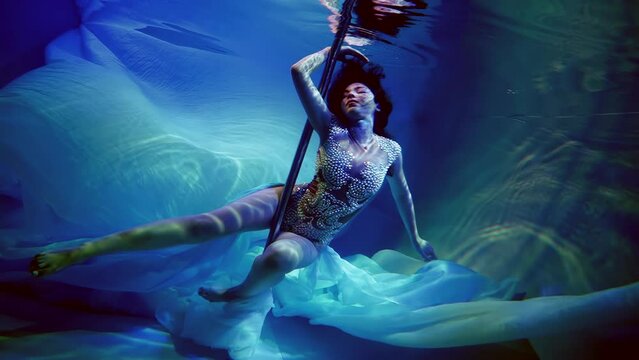 Underwater, a woman becomes part of a luminous underwater ball, where her every look and movement are reminiscent of fabulous beauty and harmony.