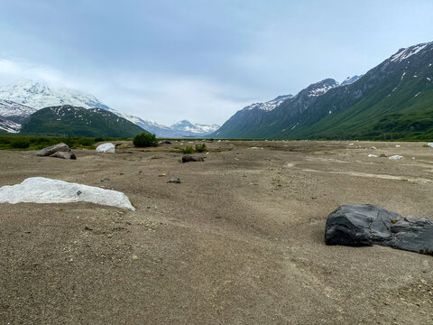Gravel valley floor near north fork Crescent River and Mount Redoubt Volcano at Lake Clark National Park in Alaska. Volcanic rock (or volcanics) is a rock formed from lava erupted from a volcano.