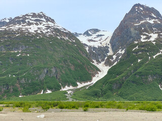 Glacier descends to gravel valley floor near north fork Crescent River and Mount Redoubt Volcano at Lake Clark National Park in Alaska. Volcanic rock (or volcanics) erupted from a volcano.