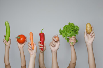Hands with fresh vegetables isolated on gray background. Organic food and healthy eating concept - obrazy, fototapety, plakaty