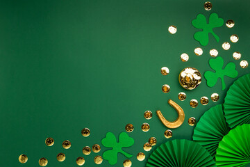 St. Patrick's Day Leprechaun Hat, Gold Coins, Shamrocks and Party Favors on Green Background.