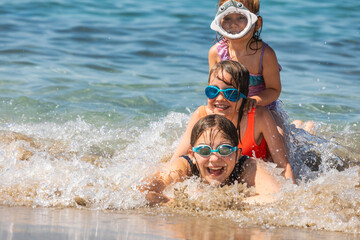 Joyful children playing in the shallow beach waves