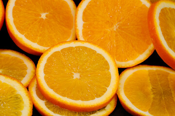 Sliced ​​orange slices close-up on a black background