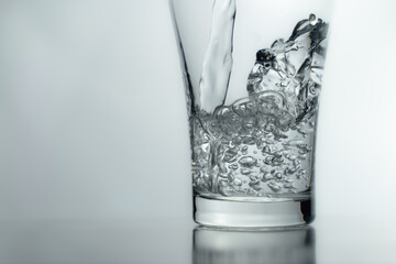 pouring water into glass on table, glass of water with splash isolated on white background. clean water for a good health. Mineral water in glass. 