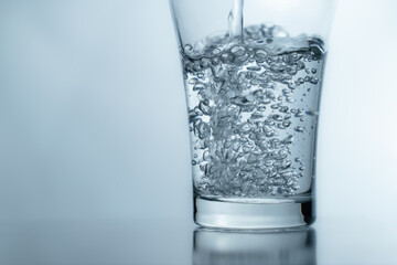 close-up Filling a glass with water showing a drink concept. bubbles in fresh water with white background. 