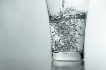 close-up Filling a glass with water showing a drink concept. bubbles in fresh water with white background. 