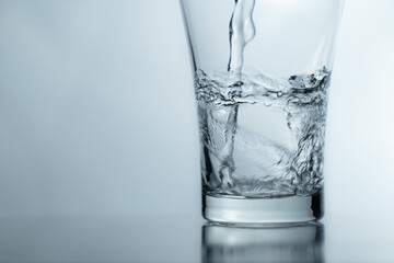 pouring water into glass on table, glass of water with splash isolated on white background. clean water for a good health. Mineral water in glass. 
