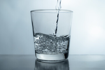 Filling a glass with water showing a drink concept. bubbles in fresh water with white background. 