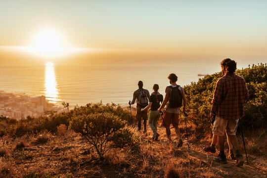 Group of friends hiking in the mountains at sunset
