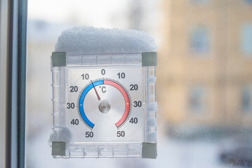 Thermometer with negative temperature and fresh snow on a window - obrazy, fototapety, plakaty