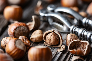 Hazelnuts with a classic silver nutcracker on wooden table. Food photography