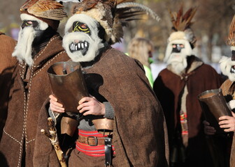Obraz premium Pernik, Bulgaria - January 26, 2024: International masquerade festival Surva in Pernik, Bulgaria. People with mask called Kukeri dance and perform to scare the evil spirits.