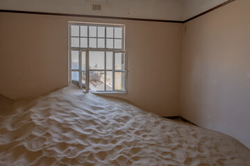 desert sand entering room of forsaken hospital at mining ghost town in desert, Kolmanskop,  Namibia