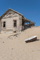 bathtub and forsaken run-down building on sand at mining ghost town in desert, Kolmanskop,  Namibia