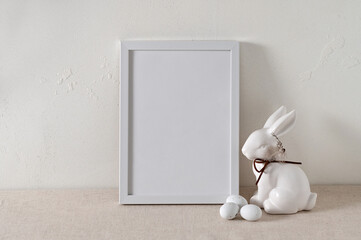 Minimalist white Easter holiday poster template, blank picture frame mockup, rabbit figurine and...