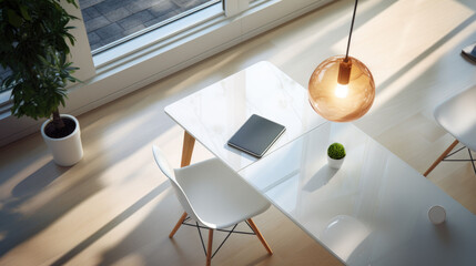 Closeup above view of a modern office glass table with laptop, pot plant and cup