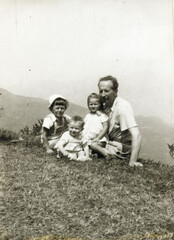 ANCIENT PHOTO WITH A FATHER AND HIS LITTLE CHILDREN ON THE MEADOW