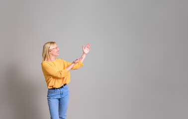 Happy young businesswoman showing and advertising new product while standing on white background