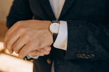 Close-up of a man's hands in a velor jacket and a watch. Men's business style and the value of time